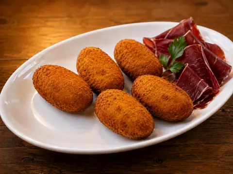 Croquetas de cecina acompañadas de lonchas de cecina